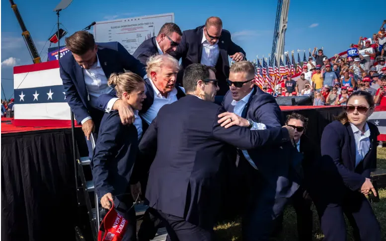 Ông Donald Trump được hộ tống ra khỏi bục sân khấu sau vụ ám sát hụt ở Butler, bang Pennsylvania, ngày 13/7/2024 (Ảnh: World Press Photo 2025) Ông Donald Trump được hộ tống ra khỏi bục sân khấu sau vụ ám sát hụt ở Butler, bang Pennsylvania, ngày 13/7/2024 (Ảnh: World Press Photo 2025)