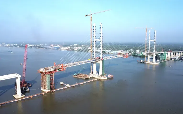 Những lớp nhựa đầu tiên đang được thảm trên nhịp chính cầu Rạch Miễu 2 nối hai tỉnh Đồng Tháp - Vĩnh Long