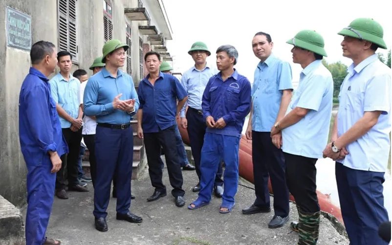 Chủ tịch UBND tỉnh Bắc Ninh Vương Quốc Tuấn (thứ 2, hàng thứ nhất từ trái sang) trò chuyện, động viên công nhân đang làm việc tại trạm bơm Trúc Tay