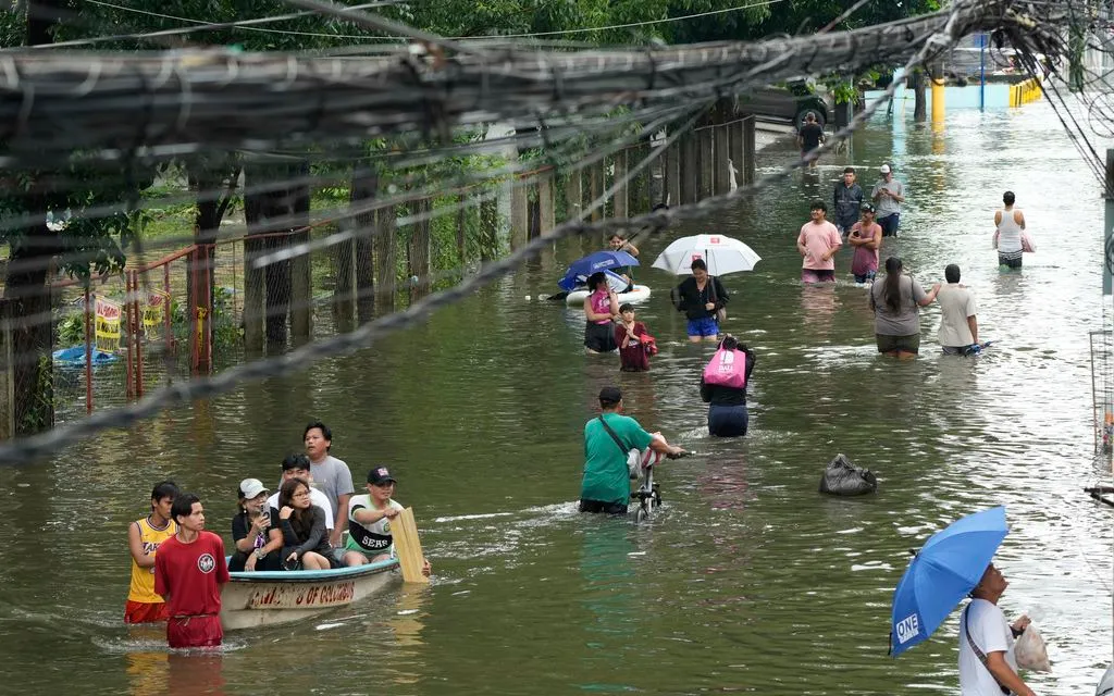 Người dân lội qua vùng ngập sau trận mưa lớn do gió mùa tây nam gây ra tại tỉnh Rizal, Philippines ngày 23/7/2025. (Ảnh: AP)