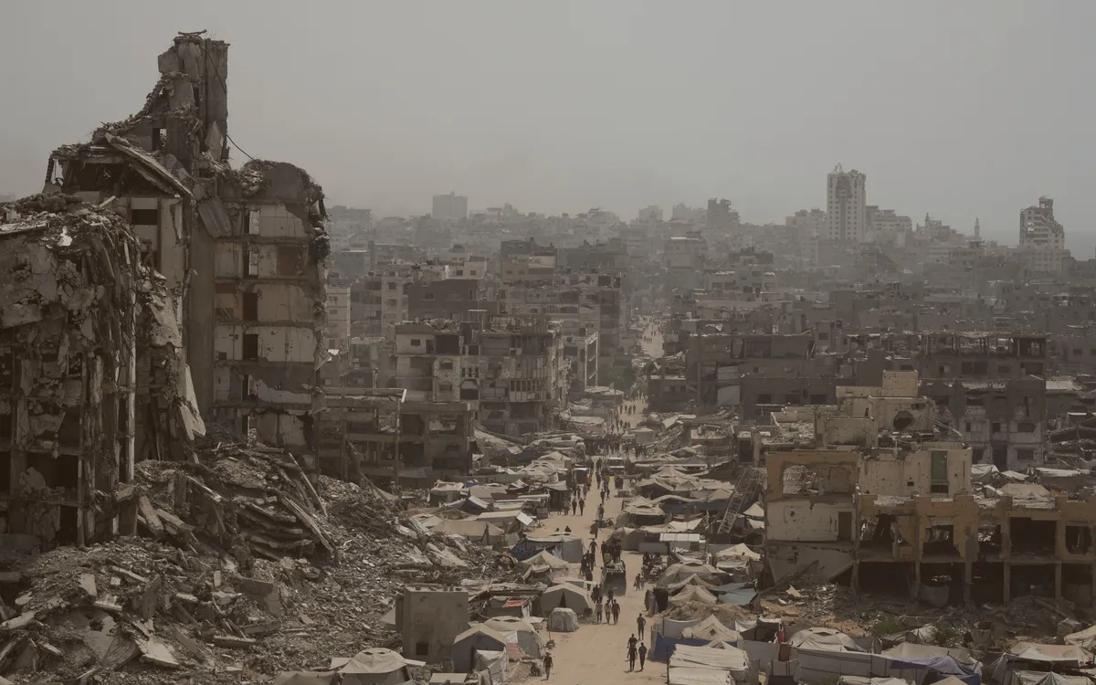 Người dân đi qua con phố đầy nhà cửa đổ nát sau đợt không kích của Israel ở Dải Gaza, ngày 29/7/2025. (Ảnh: AP) Người dân đi qua con phố đầy nhà cửa đổ nát sau đợt không kích của Israel ở Dải Gaza, ngày 29/7/2025. (Ảnh: AP)