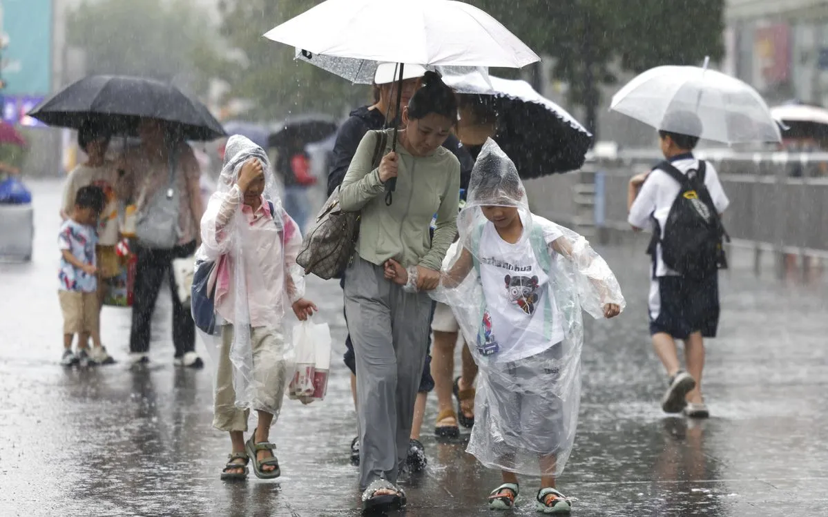Người dân đi dưới mưa gần ga đường sắt Thượng Hải ngày 30/7/2025 (Ảnh: Xinhua) Người dân đi dưới mưa gần ga đường sắt Thượng Hải ngày 30/7/2025 (Ảnh: Xinhua)