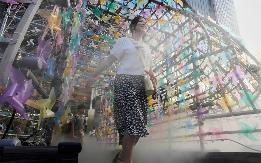 Một phụ nữ đi qua mái vòm phun sương tại trung tâm thương mại ở Tokyo ngày 25/7/2025. (Ảnh: AP) Một phụ nữ đi qua mái vòm phun sương tại trung tâm thương mại ở Tokyo ngày 25/7/2025. (Ảnh: AP)