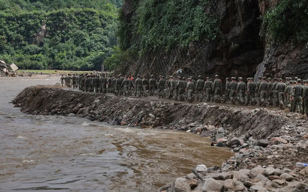 Binh sĩ di chuyển trên con đường bị hư hỏng do lũ khi tới cứu hộ người dân bị mắc kẹt ở quận Miyun, ngoại ô Bắc Kinh, ngày 29/7/2025 (Ảnh: AP)