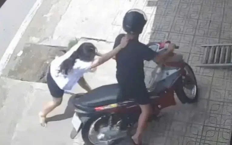Phát hiện bị cướp, nữ nhân viên chạy theo giằng co với người đàn ông trước cửa tiệm vàng. (Ảnh cắt từ camera an ninh) Phát hiện bị cướp, nữ nhân viên chạy theo giằng co với người đàn ông trước cửa tiệm vàng. (Ảnh cắt từ camera an ninh)