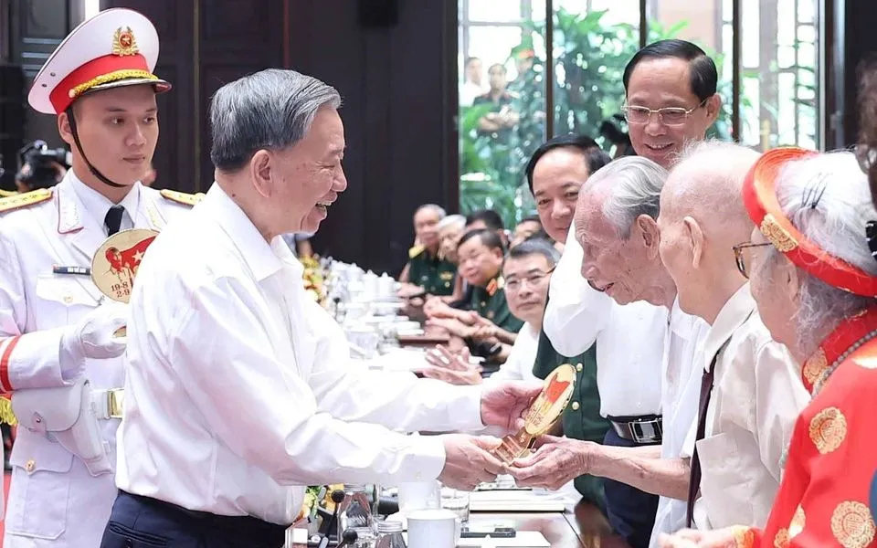 Tổng Bí thư Tô Lâm tặng quà cho cán bộ lão thành cách mạng. (Ảnh: TTXVN)