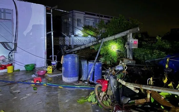 Trụ điện ngã đổ dẫn đến sự cố mất điện sau dông lốc, tối 5/8. Ảnh: TTXVN 
