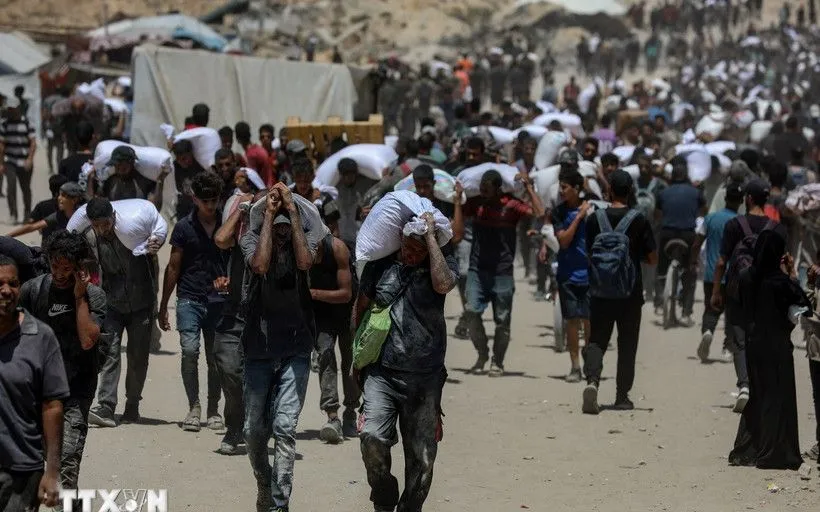 Người dân Palestine nhận hàng viện trợ nhân đạo tại Beit Lahia, phía Bắc Dải Gaza, ngày 1/8/2025 (Ảnh: THX/TTXVN)