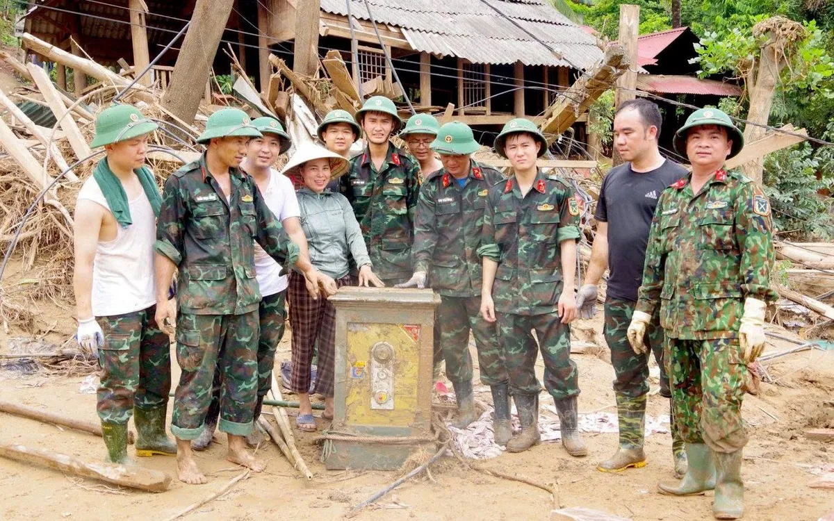 Tổ công tác trả lại két sắt cho gia đình bà Lô Thị Xuân. (Ảnh: TTXVN)
