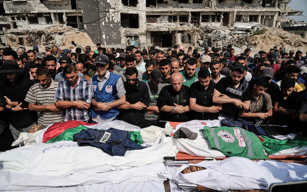 Người Palestine cầu nguyện bên thi thể các nhà báo, gồm phóng viên Al Jazeera Anas al-Sharif và Mohamed Qreiqeh, trong lễ tang gần Bệnh viện Shifa, Gaza, ngày 11/8/2025 (Ảnh: AP)