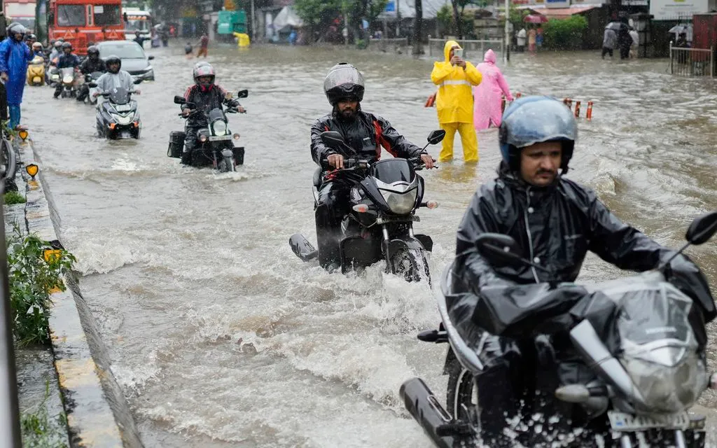 Người dân đi xe máy qua tuyến đường ngập nước trong mưa lớn ở Mumbai, Ấn Độ, ngày 18/8/2025 (Ảnh: AP/Rajanish Kakade) Người dân đi xe máy qua tuyến đường ngập nước trong mưa lớn ở Mumbai, Ấn Độ, ngày 18/8/2025 (Ảnh: AP/Rajanish Kakade)
