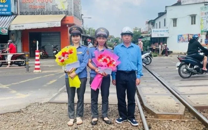 Đại diện lãnh đạo Công ty cổ phần Đường sắt Sài Gòn động viên, khen thưởng hai nhân viên gác chắn (Nguồn: Nhân Dân)