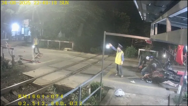 Kịp thời cứu hai người lao vào chắn đường ngang khi tàu sắp tới - Ảnh 1.