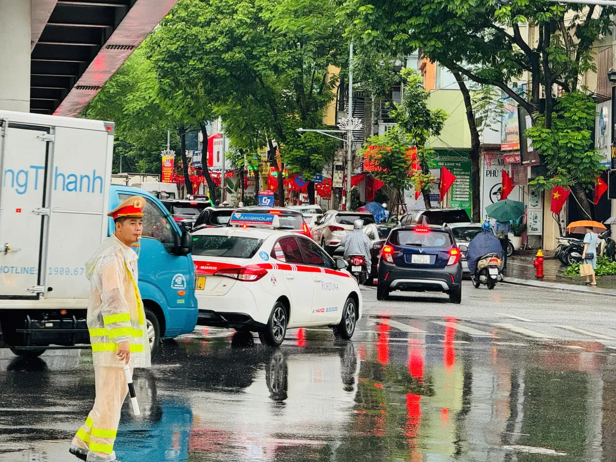 Hà Nội: CSGT căng mình phân luồng giao thông trong mưa ngập - Ảnh 2.