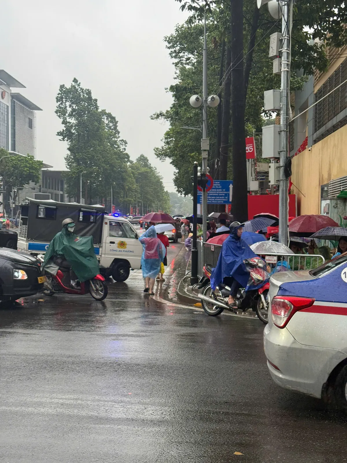 Người dân “đội mưa” giữ chỗ chờ xem sơ duyệt diễu binh, diễu hành A80 - Ảnh 2.