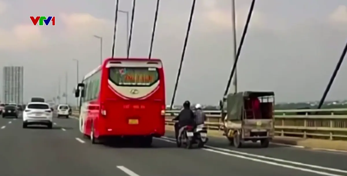 Lấn làn thiếu quan sát, hai xe máy ngã trước đầu ô tô trên cầu Nhật Tân - Ảnh 1.