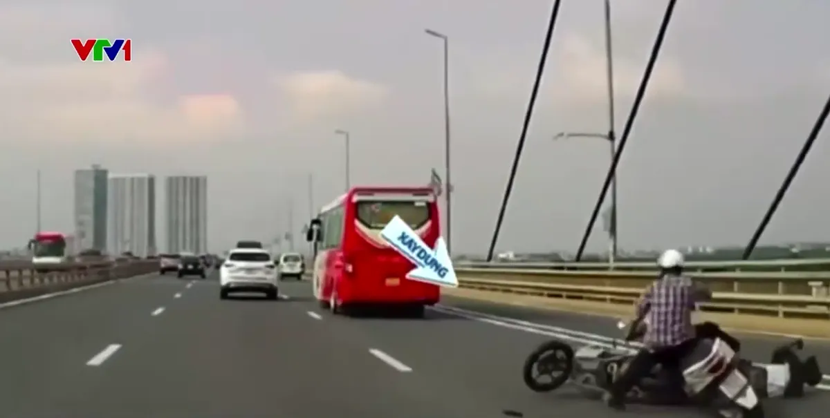 Lấn làn thiếu quan sát, hai xe máy ngã trước đầu ô tô trên cầu Nhật Tân - Ảnh 2.