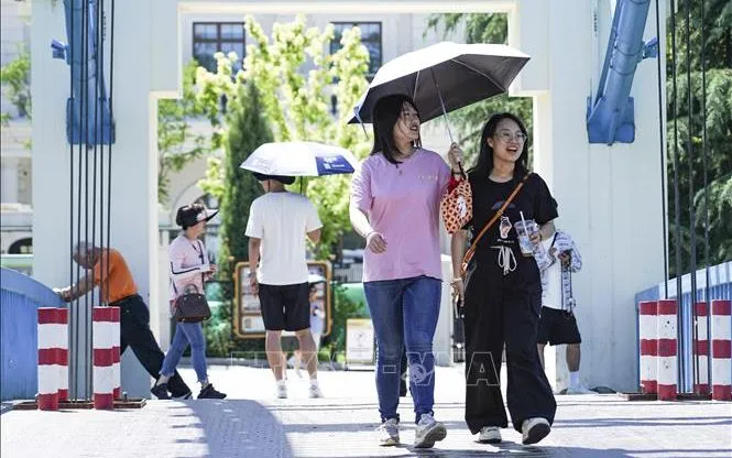 Người dân che ô tránh nắng tại thủ đô Bắc Kinh, Trung Quốc. Ảnh: THX/TTXVN Người dân che ô tránh nắng tại thủ đô Bắc Kinh, Trung Quốc. Ảnh: THX/TTXVN