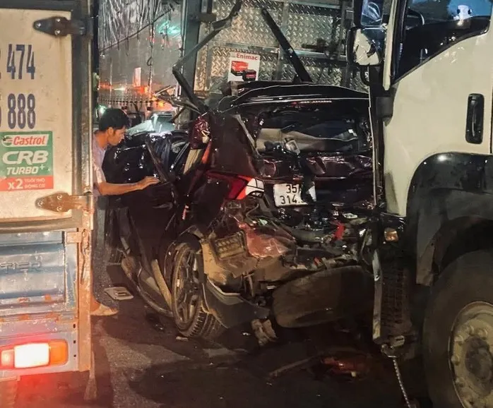 Ô tô 7 chỗ bị xe tải tông bẹp dúm khi chờ đèn đỏ, 3 người thương vong - Ảnh 1.