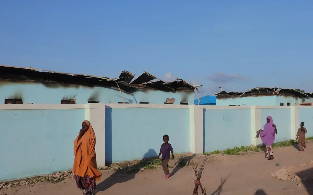 Người dân đi ngang qua những ngôi nhà bị đốt cháy sau cuộc tấn công của Boko Haram vào ngôi làng Darul Jamal, bang Borno, Đông Bắc Nigeria đêm 5/9 (Ảnh: AP)