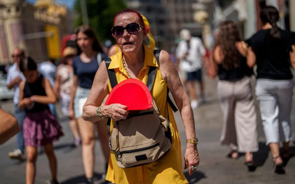 Một phụ nữ quạt mát trong đợt nắng nóng ở Madrid, Tây Ban Nha ngày 10/7/2023 (Ảnh: AP)