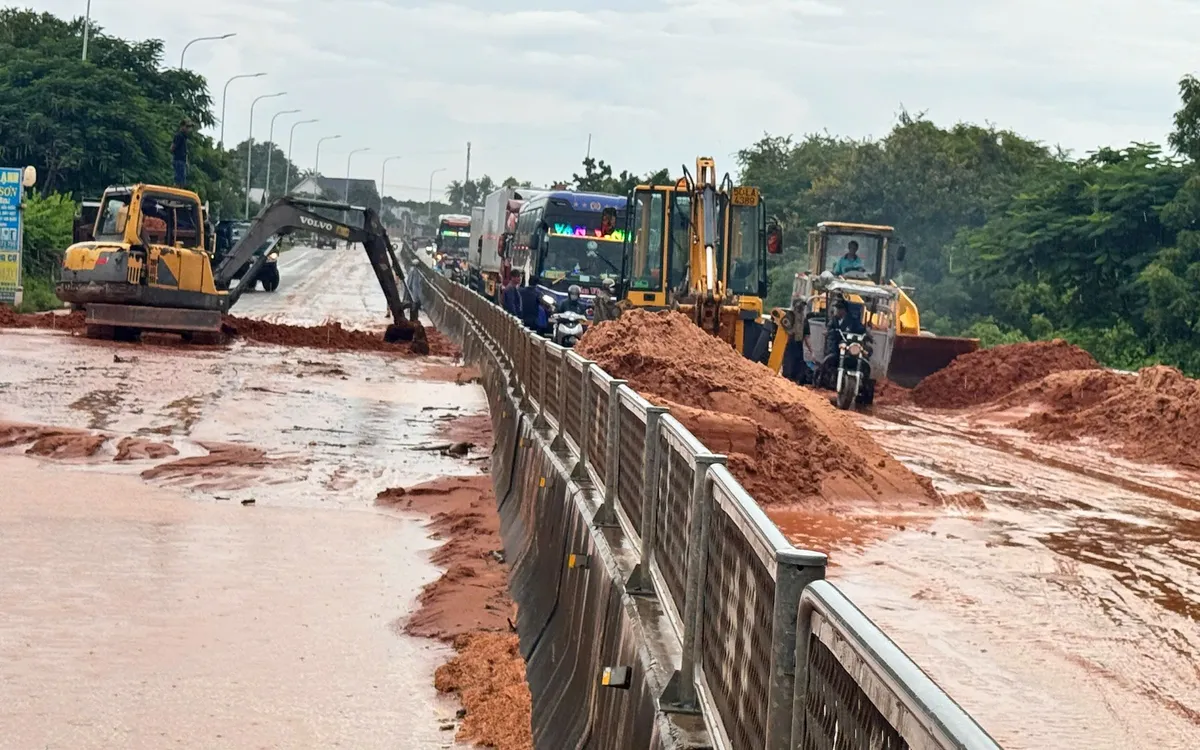 Các phương tiện máy móc đang dọn dẹp khu vực cát tràn xuống Quốc lộ. Ảnh: B.H. Các phương tiện máy móc đang dọn dẹp khu vực cát tràn xuống Quốc lộ. Ảnh: B.H.