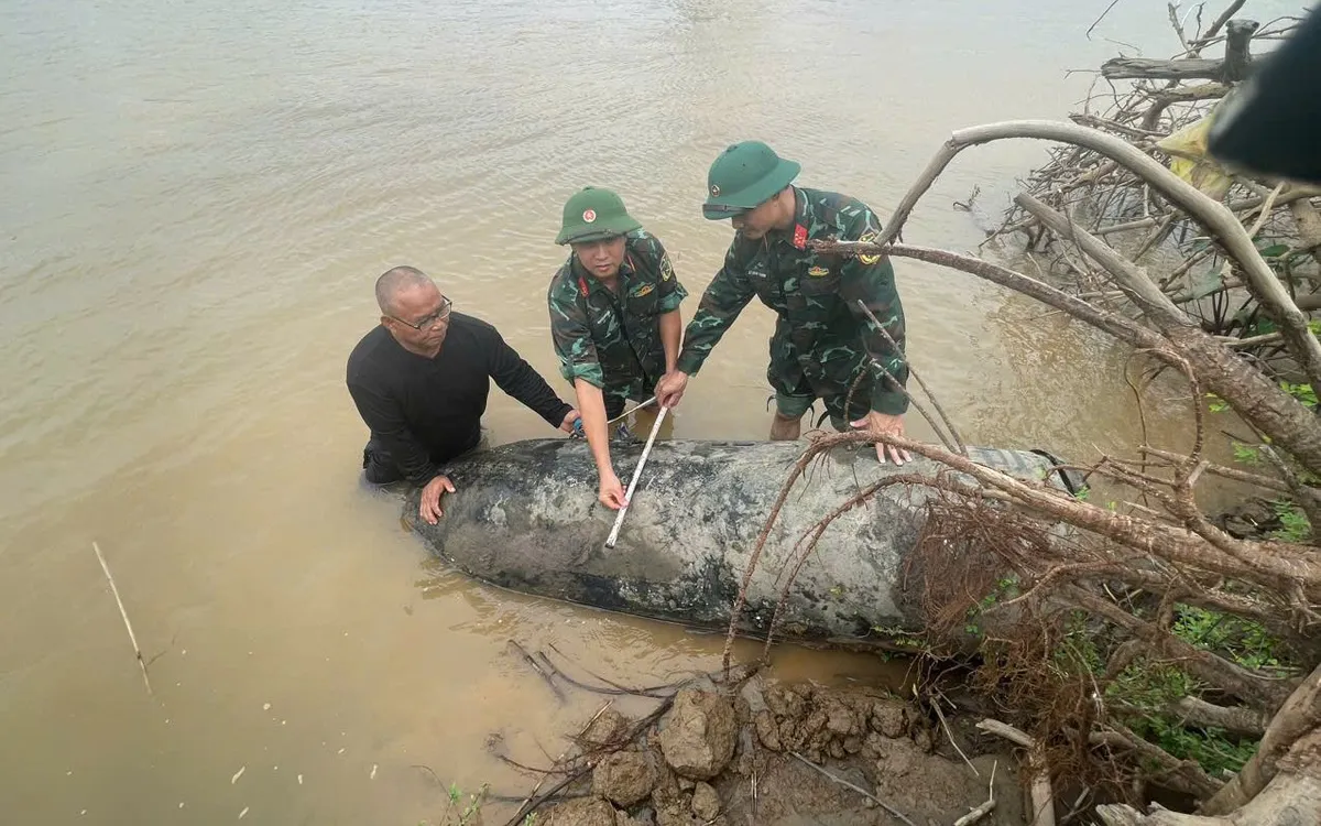 Lực lượng chức năng tiến hành đo đạc kích thước 2 quả bom. Ảnh: Phạm Luân