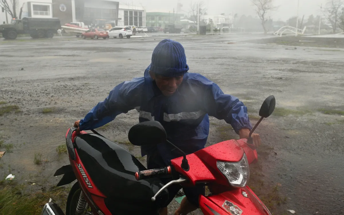 Người đàn ông dắt xe máy trong mưa lớn do bão Usagi tại Santa Ana, tỉnh Cagayan, miền Bắc Philippines, ngày 14/11/2024 (Ảnh: AP) Người đàn ông dắt xe máy trong mưa lớn do bão Usagi tại Santa Ana, tỉnh Cagayan, miền Bắc Philippines, ngày 14/11/2024 (Ảnh: AP)