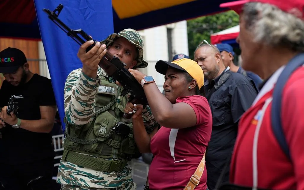 Một thành viên Dân quân Bolivar hướng dẫn phụ nữ sử dụng vũ khí trong cuộc tập trận tại Caracas, Venezuela, ngày 20/9/2025. (Ảnh: AP)