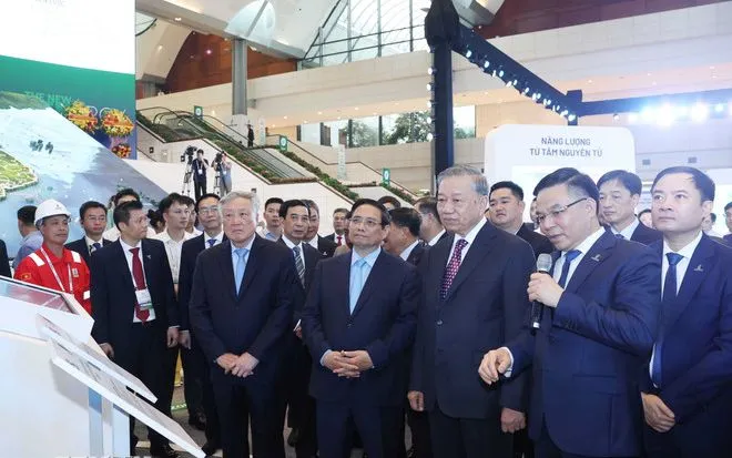 Tổng Bí thư Tô Lâm, Thủ tướng Phạm Minh Chính và các đại biểu tham quan triển lãm thành tựu khoa học, công nghệ của Tập đoàn Công nghiệp - Năng lượng quốc gia Việt Nam. (Ảnh: TTXVN)