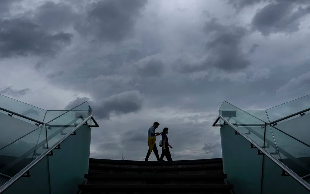 Người đi bộ dọc bờ biển Cảng Victoria trước khi siêu bão Ragasa đổ bộ Hong Kong ngày 23/9/2025. (Ảnh: AP)