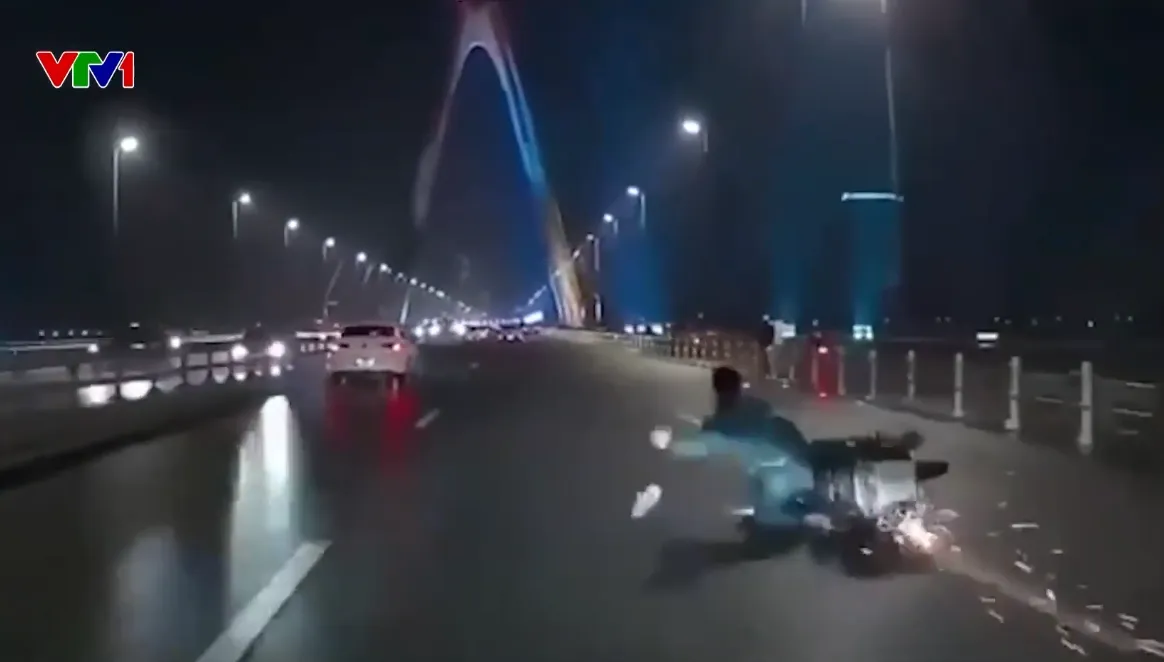 Đi vào làn ô tô trên cầu Nhật Tân, nam thanh niên đi xe máy va vào dải phân cách ngã văng ra đường - Ảnh 1.