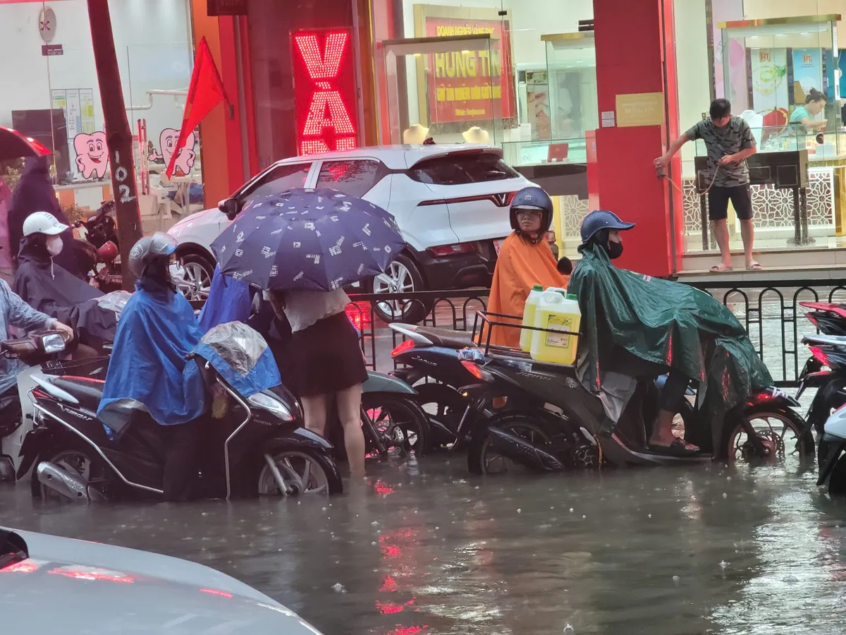 Biển nước nhấn chìm đường phố, người dân chật vật, xe máy nằm la liệt - Ảnh 4.