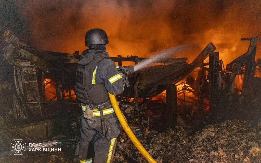 Lính cứu hỏa cố gắng dập tắt đám cháy sau cuộc không kích của Nga ở Kharkov, Ukraine (Ảnh: AP)