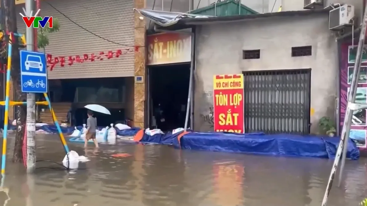 Mưa lớn gây ngập sâu, người dân Hà Nội dùng máy bơm, đắp bao cát ngăn nước tràn vào nhà- Ảnh 1.