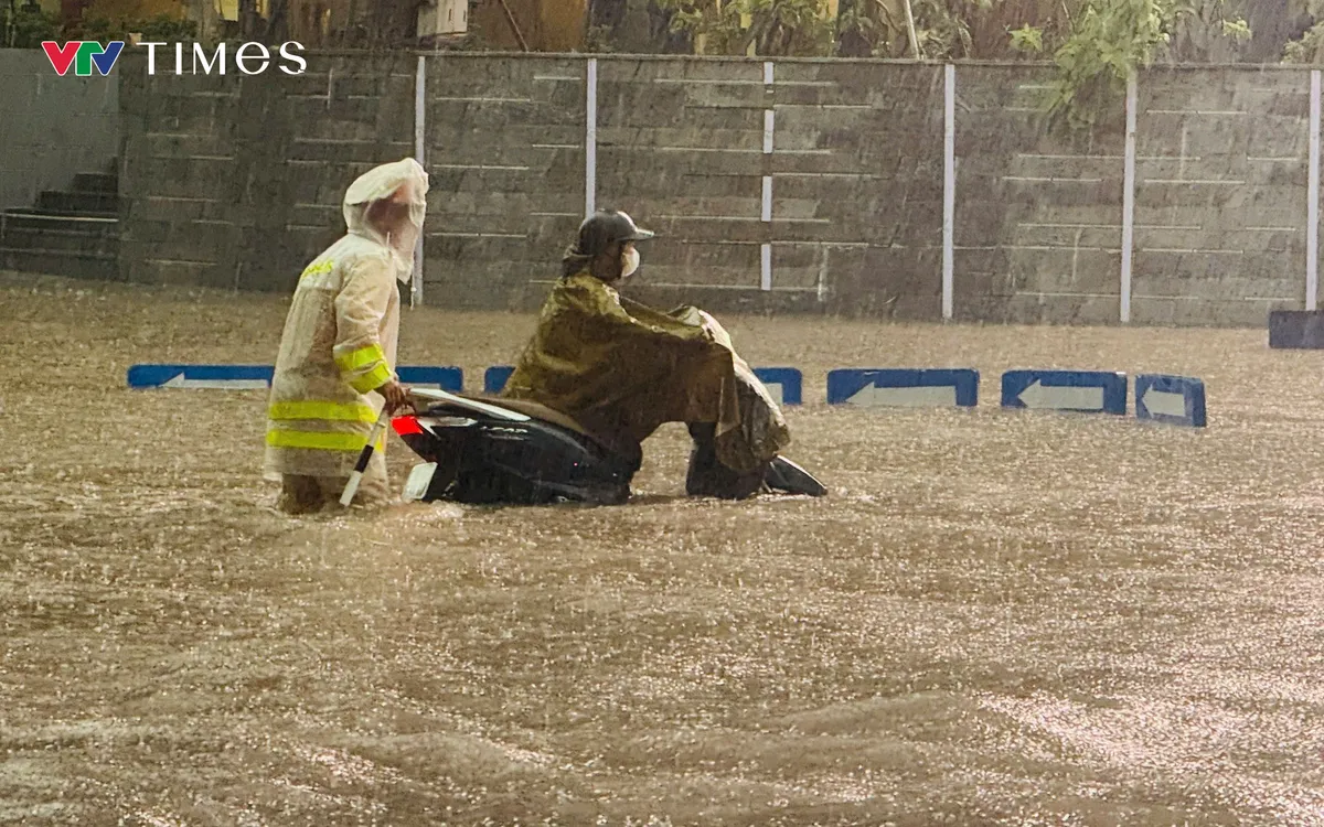 Một xe máy đi vào điểm ngập sâu đang được CSGT hỗ trợ.