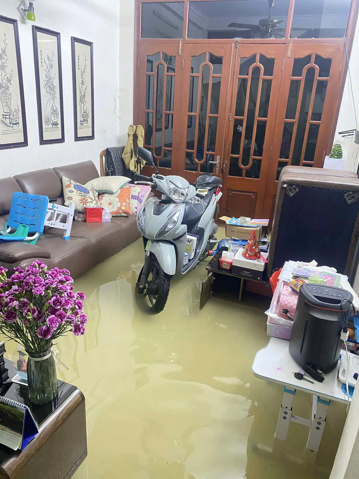 Ngập úng nhiều nhà bị nước tràn vào, gây khó khăn cho cuộc sống của người dân - Ảnh 1.