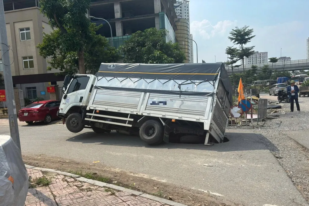 Hà Nội: Xe tải bị lún xuống hố giữa phố, xe cứu hộ cũng gặp sự cố - Ảnh 2.