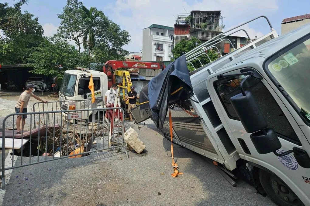 Hà Nội: Xe tải bị lún xuống hố giữa phố, xe cứu hộ cũng gặp sự cố - Ảnh 1.