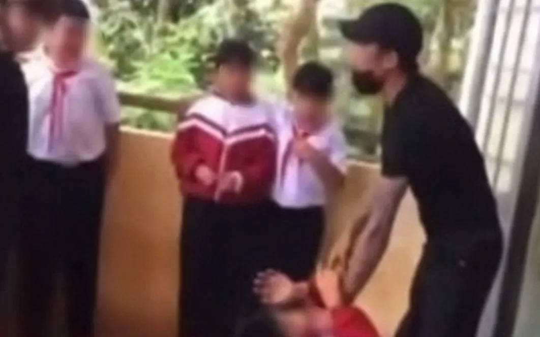 Người đàn ông túm cổ áo, liên tục dọa nạt một học sinh. (Ảnh chụp màn hình)