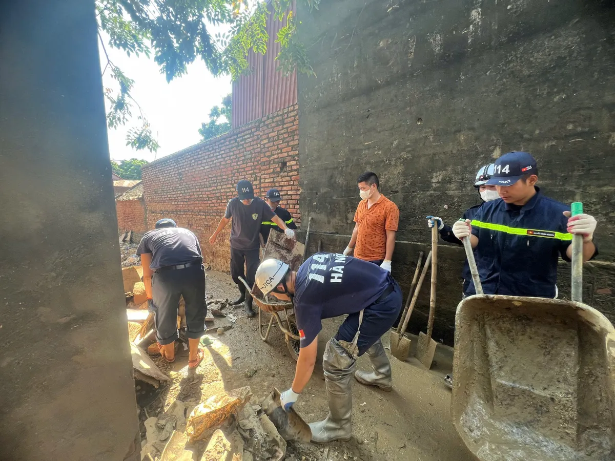 Công an Thủ đô tiếp tục ra quân hỗ trợ người dân khắc phục hậu quả sau mưa lũ - Ảnh 1.