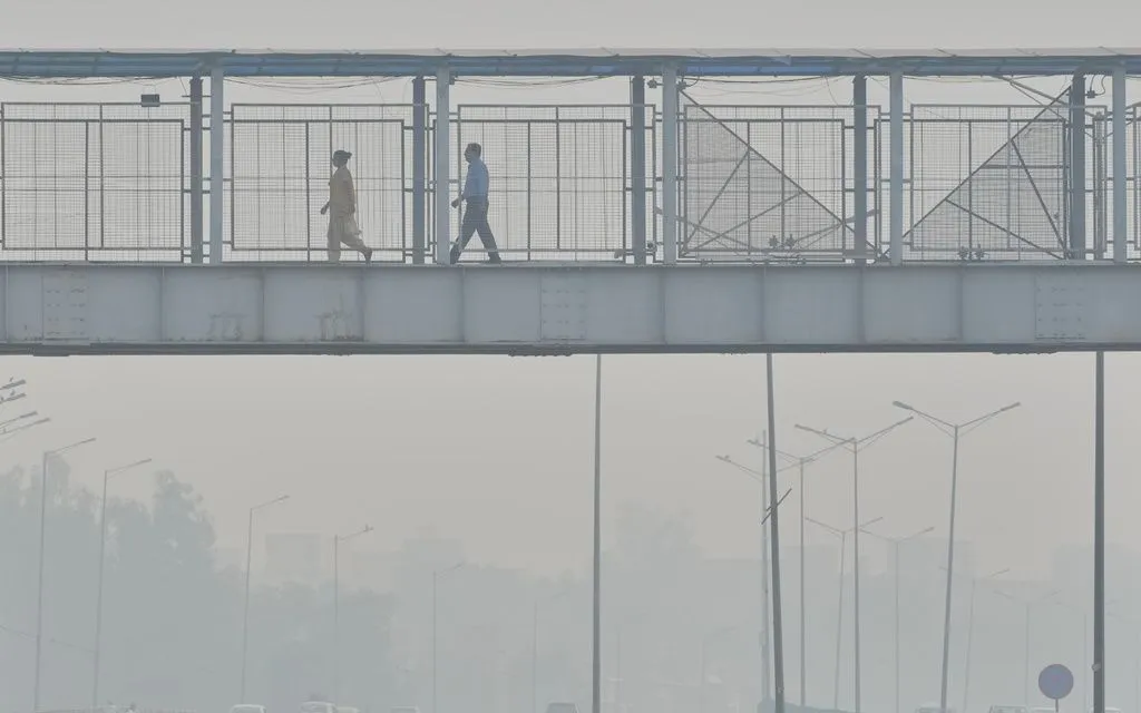 Người dân đi qua cầu vượt trong làn sương mù buổi sáng ở New Delhi, Ấn Độ, ngày 21/10/2025. (Ảnh: AP) Người dân đi qua cầu vượt trong làn sương mù buổi sáng ở New Delhi, Ấn Độ, ngày 21/10/2025. (Ảnh: AP)