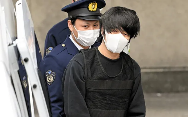 Cảnh sát áp giải Tetsuya Yamagami ra khỏi đồn cảnh sát Nara (Ảnh tư liệu: Asahi Shimbun)