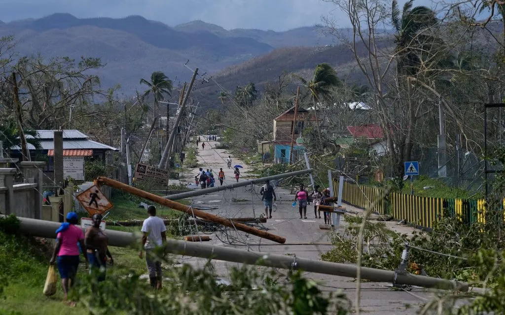 Người dân đi qua khu vực Lacovia Tombstone, Jamaica, sau bão Melissa, ngày 29/10/2025. (Ảnh: AP)