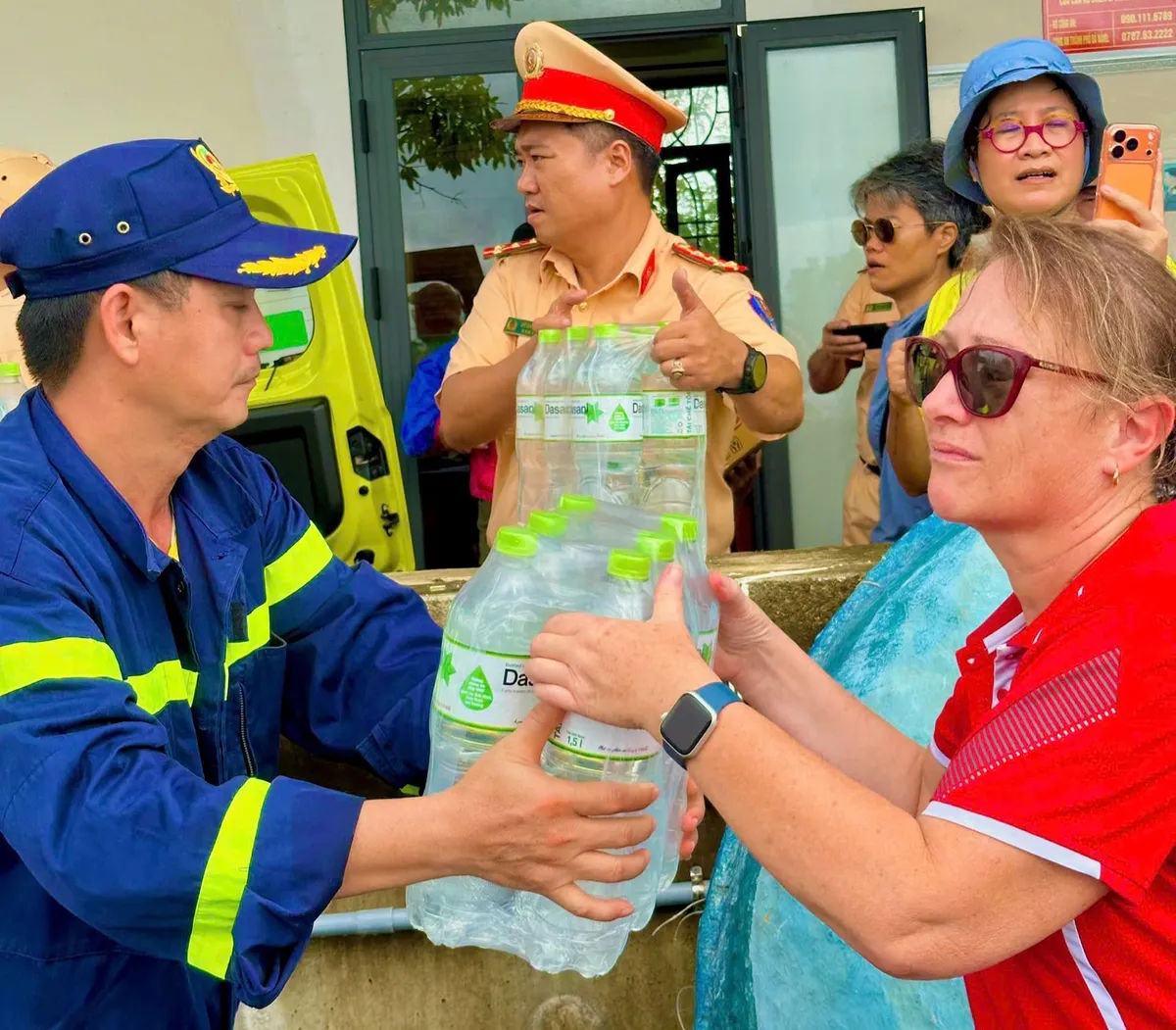Ấm lòng phố cổ: Du khách quốc tế chung tay cùng người dân Hội An khắc phục hậu quả mưa lũ - Ảnh 1.