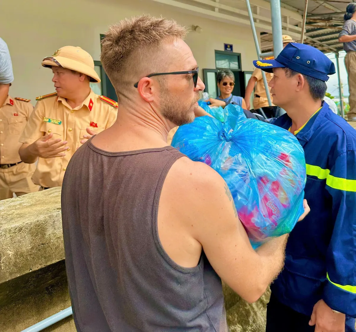 Ấm lòng phố cổ: Du khách quốc tế chung tay cùng người dân Hội An khắc phục hậu quả mưa lũ - Ảnh 3.