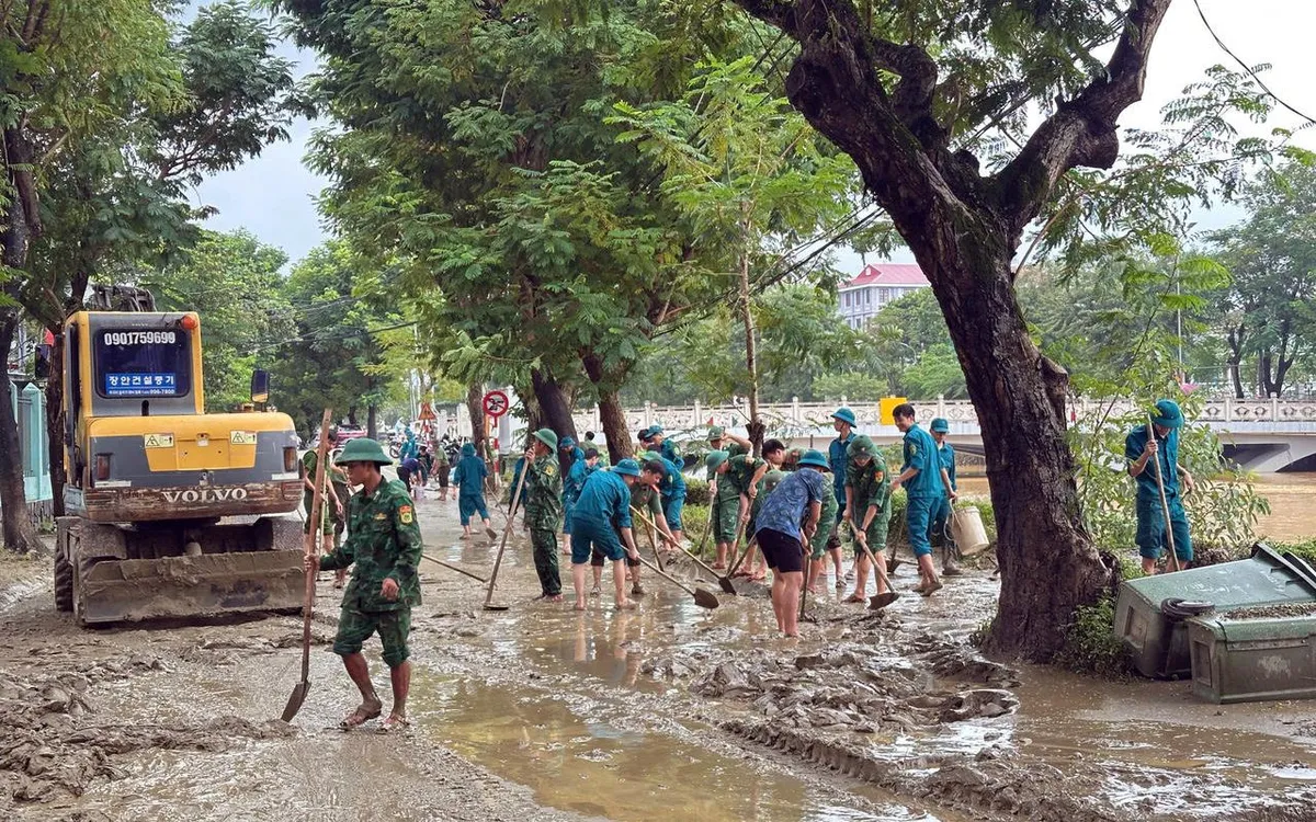 Bộ đội biên phòng TP Huế cùng với lực lượng chính quyền địa phương dọn dẹp tại đường Phan Chu Trinh, phường Thuận Hóa, TP Huế. Ảnh: VGP