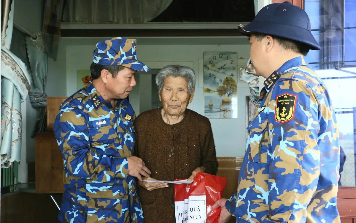 Đồng chí Đại tá Vũ Đình Hiển, PTL- TMT Vùng thăm, động viên, trao tiền và vật chất của Quân chủng Hải quân đến gia đình cụ Lê Thị Ngọ, vợ liệt sĩ Đinh Ngọc Đoàn bị thiệt hại sau mưa, lũ tại xã Hòa Tiến, thành phố Đà Nẵng