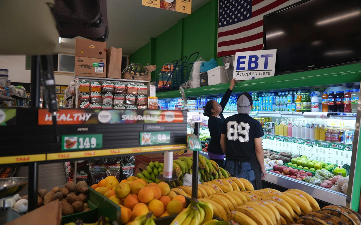 Quản lý chợ El Recuerdo dựng biểu ngữ "EBT (chuyển khoản phúc lợi điện tử) được chấp nhận tại đây" tại Los Angeles sau khi hai thẩm phán liên bang ra lệnh cho chính quyền Tổng thống Donald Trump tiếp tục tài trợ cho SNAP trong thời gian chính phủ đóng cửa (Ảnh: AP)