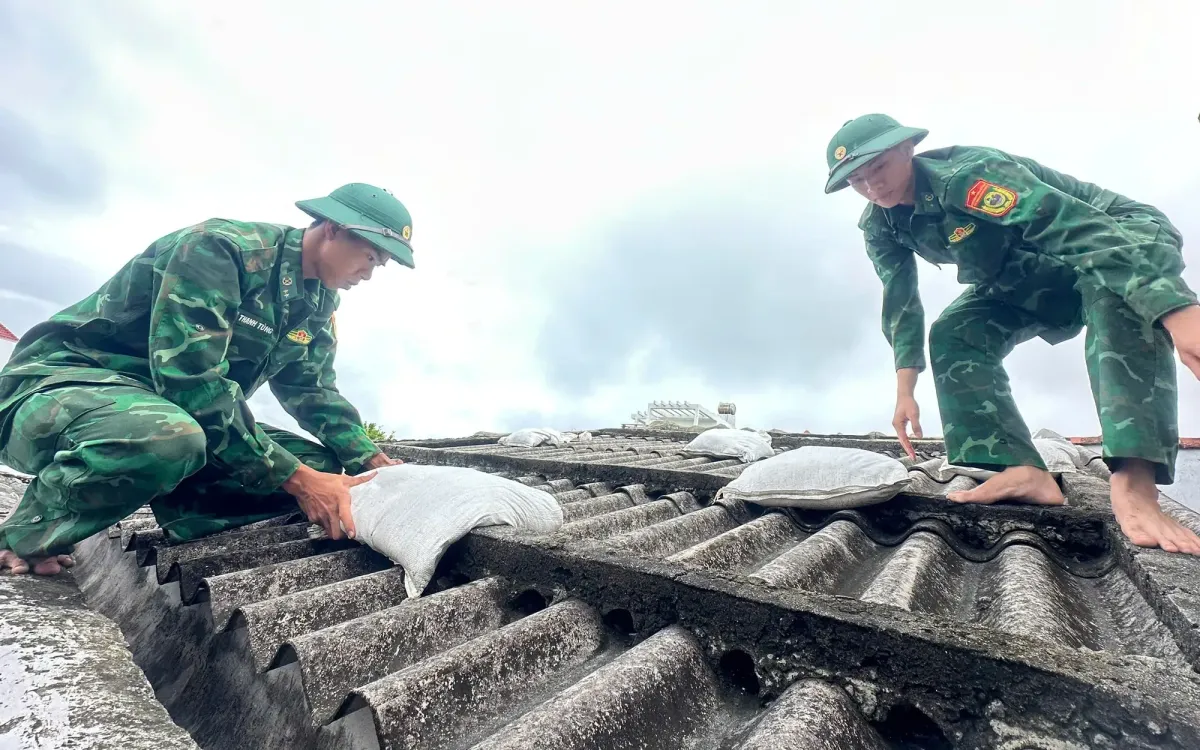 Bộ đội Biên phòng Lý Sơn giúp dân chằng chống nhà cửa chống bão số 13. (Ảnh: PLO)